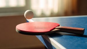 Paleta de ping pong sobre una mesa de tenis de mesa azul